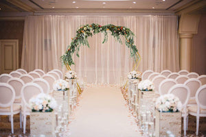 gold double hexagonal wedding arch at an indoor venue