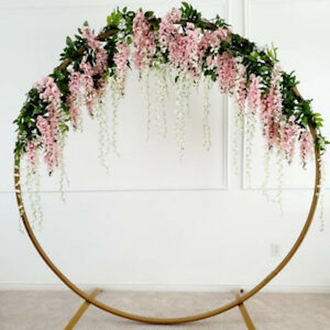 Modern Gold-Coated Round geometric Wedding Arch with pink flowers in front of a white backdrop